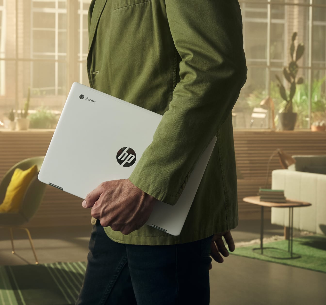 Mies kävelee työtilassa HP Chromebook mukanaan. Pitkän akunkeston ansiosta Chromebook on helppo ottaa mukaan.